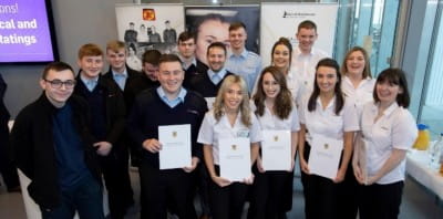 15 apprentices, some who are holding up certificates