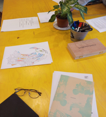 Artwork and books laid out on table